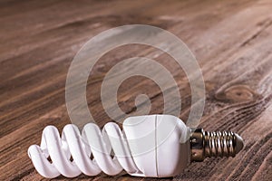 Energy saving lamp on a wooden background