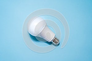 Energy saving light bulb on blue background. Savings