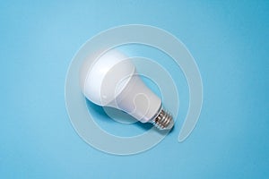 Energy saving light bulb on blue background. Savings