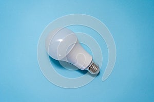 Energy saving light bulb on blue background. Savings