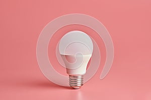 Energy saving light bulb, copy space, pink background. Minimal idea concept