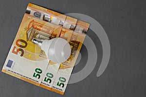 Energy saving light bulb and euro banknotes. Energy saving and savings concept