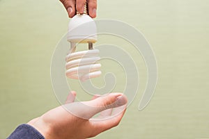 Energy saving light bulb in the hands of a man