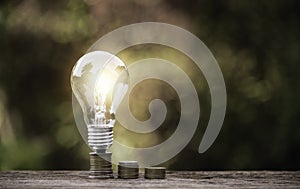Energy saving light bulb  stacks of coins idea save money concept