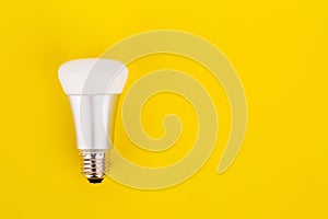 Energy saving wifi light bulb on yellow background.