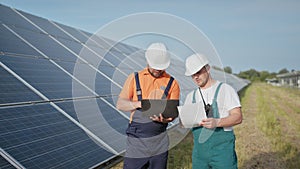 Energy specialist using digital tablet reading information to check the efficiency of solar panel construction. Green