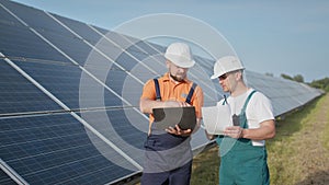 Energy specialist using digital tablet reading information to check the efficiency of solar panel construction. Green