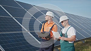 Energy specialist using digital tablet reading information to check the efficiency of solar panel construction. Green