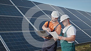 Energy specialist using digital tablet reading information to check the efficiency of solar panel construction. Green