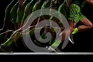 Energy and strength. Cropped image of athletic, muscular male legs in motion, running against black background with
