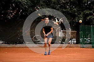 Energy woman tennis player with racket ready to hit a tennis ball.