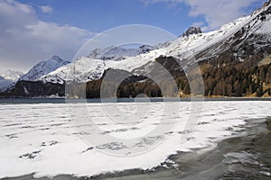 Engadin valley in Switzerland Sils Maria village with snow on Alp mountains and frozen lake