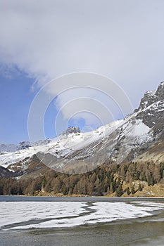 Engadin valley in Switzerland Sils Maria village with snow on Alp mountains and frozen lake