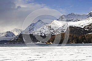 Engadin valley in Switzerland Sils Maria village with snow on Alp mountains and frozen lake