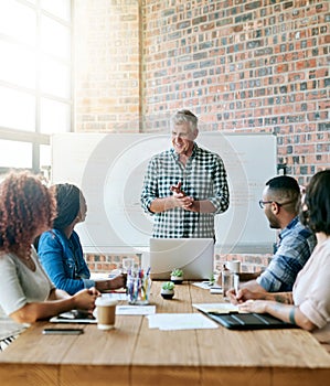 Engage the brains around you. a businessman giving a presentation in the boardroom.