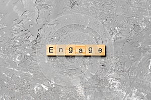 ENGAGE word written on wood block. ENGAGE text on cement table for your desing, concept