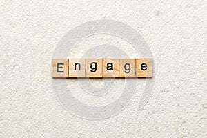 ENGAGE word written on wood block. ENGAGE text on cement table for your desing, concept