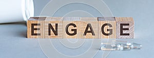 ENGAGE word written on wood block. Front view. ENGAGE text on grey background for your desing, concept