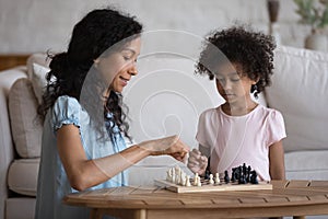 Engaged African mother teaching focused clever preschool daughter