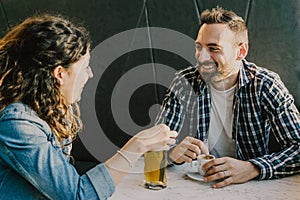 Engaged couple laughs and jokes in a bar - Friends have fun while having a drink in a coffee bar