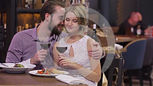 Engaged couple with wine glasses in restaurant