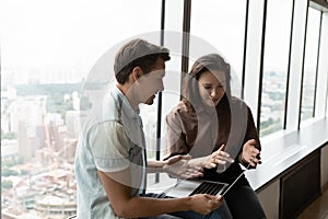 Engaged office coworkers discussing work project at brief meeting