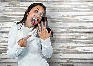 Engaged Woman with ring excited against wood