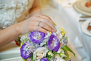 Engagement flowers .The girl and the boy put their hands on colorfull roses. Bride and groom with Engagement gold rings put their