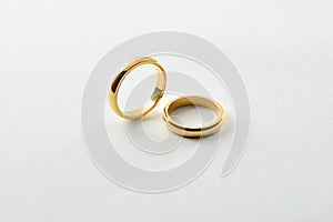 Engagement gold rings standing and lying down isolated over white