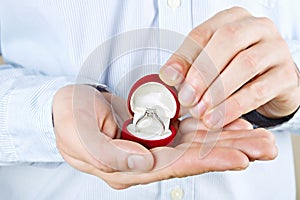 Engagement / marriage / wedding proposal scene. Close up of man handing the expensive gold platinum diamond ring to his bride.