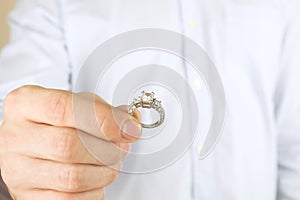 Engagement / marriage / wedding proposal scene. Close up of man handing the expensive gold platinum diamond ring to his bride.