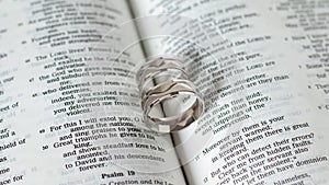 Engagement marriage wedding rings white gold on open Bible Book. Blessing and gift from God Jesus Christ biblical concept