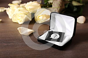 Engagement ring box, flowers on the dark wooden background