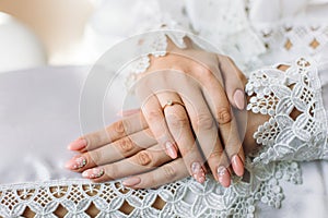 Engagement ring on bride`s finger. Beautiful lace on the dress.