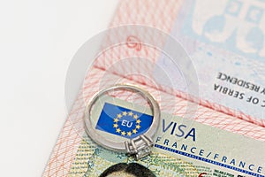 An engagement ring on a European visa stamp as a symbol of emigration or marriage