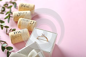 Engagement ring and text WILL YOU MARRY ME? on color background