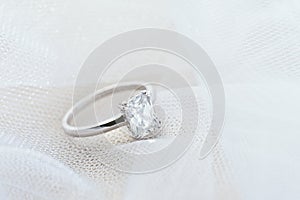 Engagement ring on white veil