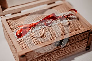 Engagement rings on a wooden box and a red bow