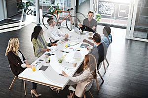 Engaging with bold ideas around the table. Shot of a group of businesspeople having a meeting in a boardroom.