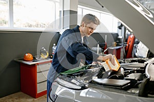 Engine air filter replacement concept, auto mechanic at work