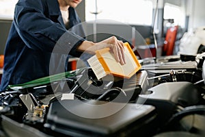 Engine air filter replacement concept, closeup shot of auto mechanic at work