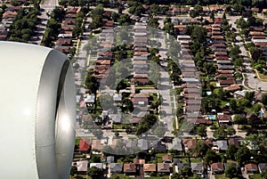 Engine of airplane flying of rooftops of big city