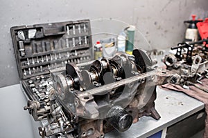 Engine crankshaft, valve cover, pistons. mechanic repairman at automobile car engine maintenance repair work