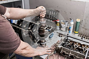 Engine crankshaft, valve cover, pistons. mechanic repairman at automobile car engine maintenance repair work