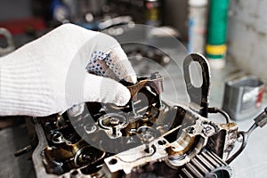 Engine crankshaft, valve cover, pistons. mechanic repairman at automobile car engine maintenance repair work