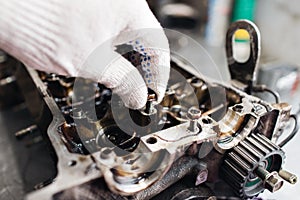 Engine crankshaft, valve cover, pistons. mechanic repairman at automobile car engine maintenance repair work