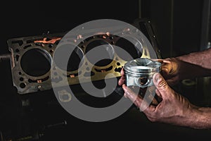 Engine cylinder in the hands of a mechanic. Auto engine repair services