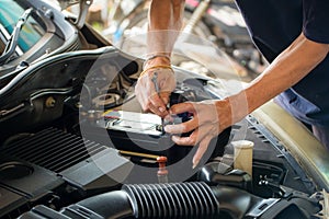 Engine engineer is replacing car battery because car battery is depleted.