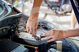 Engine engineer is replacing car battery because car battery is depleted. photo