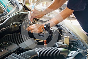 Engine engineer is replacing car battery because car battery is depleted. photo